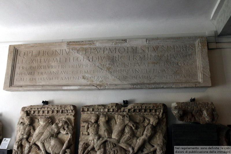 Dedica a Quinto Petronio Modesto recuperata nel Teatro romano, una delle tre conservate: un'altra al Lapidario Terestino e la terza al teatro Romano stesso: questa è parzialmente ricostruita in gesso